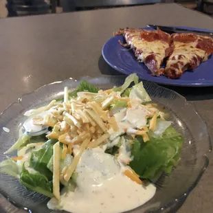 a plate of salad and a slice of pizza