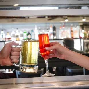 two people clinking glasses of beer