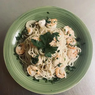 a plate of pasta with shrimp and parsley