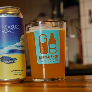 a glass of beer and a can of pleasure wave