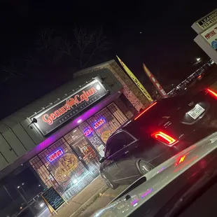 a car outside a restaurant at night