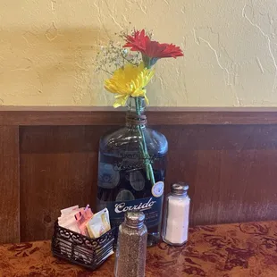 a vase of flowers and salt on a table