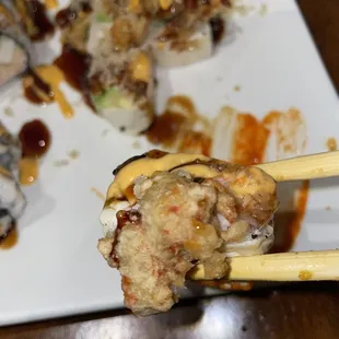 a plate of sushi with chopsticks