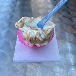 ice cream in a pink bowl with a blue spoon