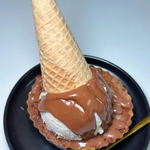 an ice cream cone with chocolate sauce