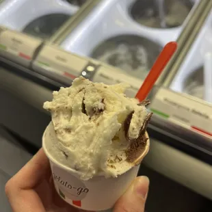 a hand holding a cup of ice cream