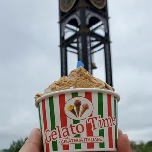a hand holding a cup of gelato