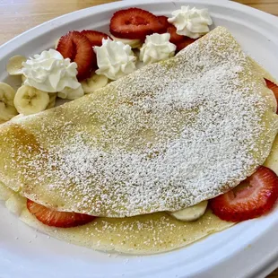 a crepe with strawberries and whipped cream