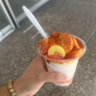 a hand holding a cup of gelu