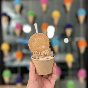 a hand holding a cone of ice cream