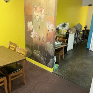 a dining room with a painting on the wall