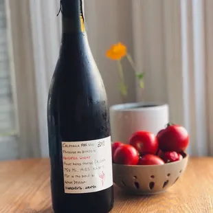 a bowl of cherries and a bottle of wine