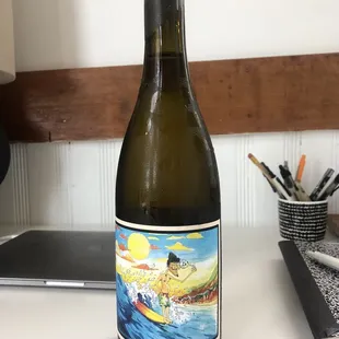 a bottle of wine sitting on a desk