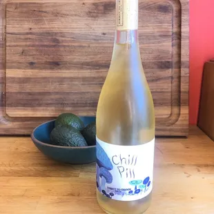 a bottle of wine and a bowl of fruit