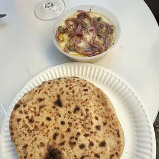 a plate of flat bread and a bowl of salad