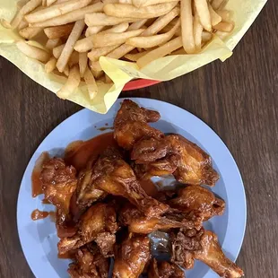 a plate of chicken wings and french fries