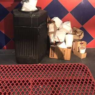 a trash can and boxes of toilet paper
