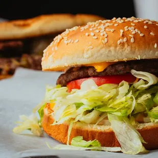 a hamburger with lettuce, tomato, and cheese