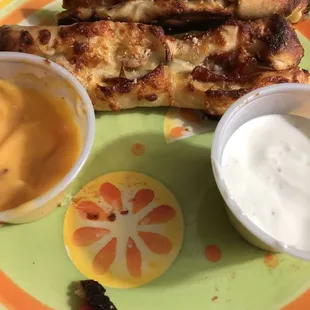 a plate of grilled meat and sauces