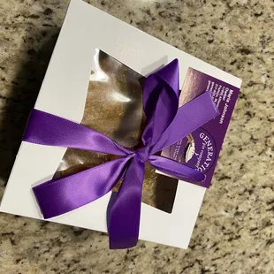 a purple ribbon wrapped in a gift box