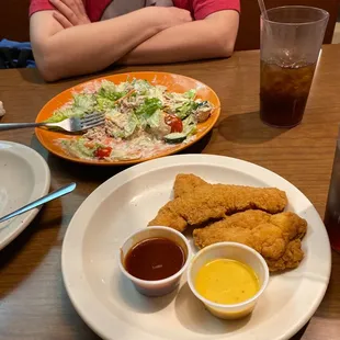 a plate of fried chicken and a salad