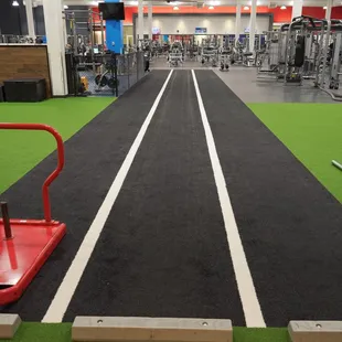 The turf area at our East Harry location provides you with lots of equipment to stretch and workout. Ready to test the sled push?