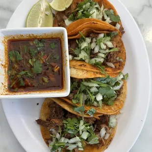 a plate of tacos and a bowl of salsa
