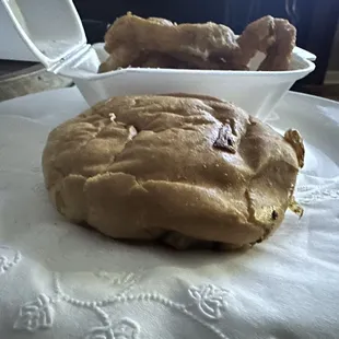 a close up of a sandwich and a bowl of fried chicken