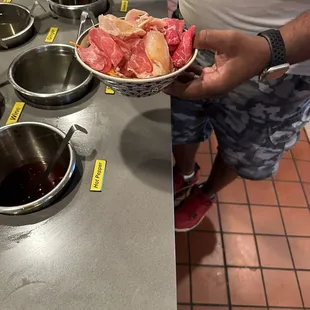 ows a man holding a bowl of raw meat