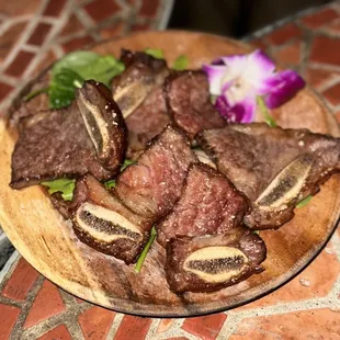 a plate of steak with a flower