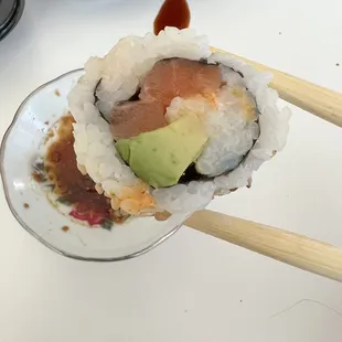 a plate of sushi with chopsticks