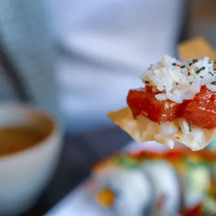 a person holding a piece of sushi