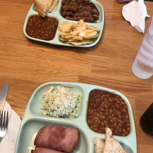 a plate of baked beans, ham, beans, and a sandwich