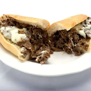 A plate featuring a delectable half of a cheesesteak sub from Genova&apos;s To Go. Pure sandwich perfection!