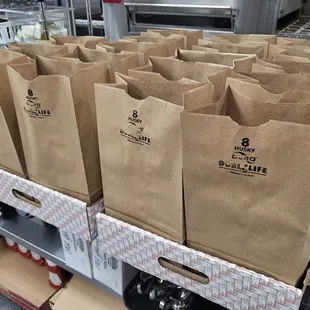 Enjoy these bagged lunches prepared by Genova&apos;s To Go. including a sandwich, a drink, and a bag of chips.