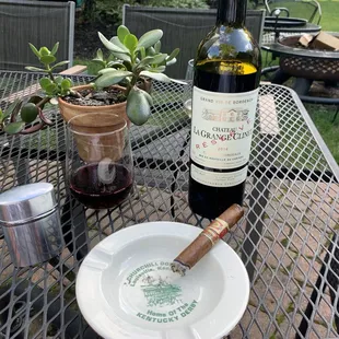 a plate with a cigar and a bottle of wine