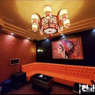 a living room with orange couches and a chandelier
