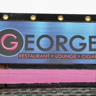 a neon sign on the roof of a restaurant