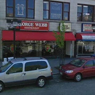 two cars parked in front of a restaurant