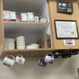 a shelf of coffee cups and mugs