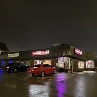 a red car parked in front of the restaurant