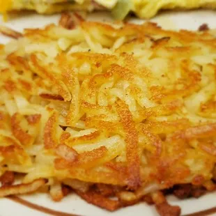 a plate of hash browns with a side of potatoes