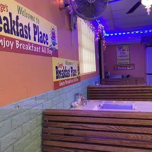 Inside. One row of four small booths and to the right is a very small counter space with the stools.