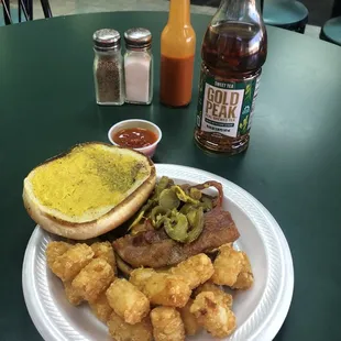 Bacon cheese burger with mustard, pickles, and jalapeños with a side of tater tots