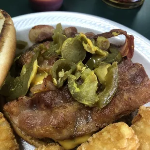 Bacon cheese burger with mustard, pickles, and jalapeños with a side of tater tots