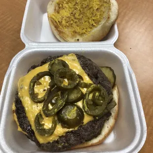 Double meat cheeseburger with mustard, pickles, and jalapeños - Delicious