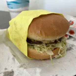 a hamburger wrapped in a yellow wrapper