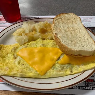 Bacon, egg, and cheese omelet with home fries and toast