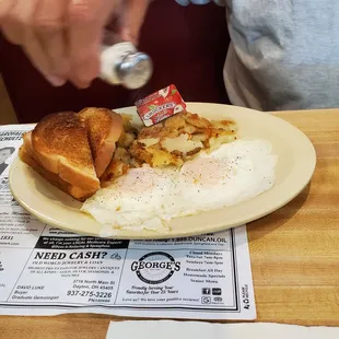 2 fried eggs over easy, fried potatoes and toast