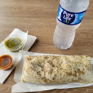 Carne Asada burrito with a water and two different salsa varieties.
